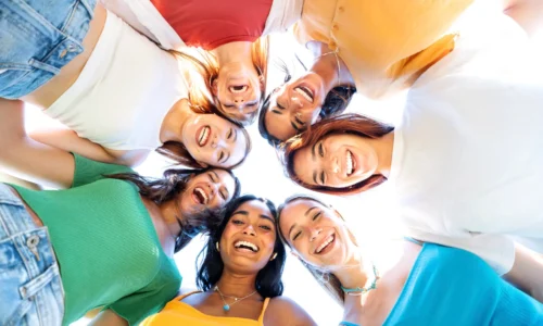 Multicultural young women smiling at camera together - Happy girls taking selfie portrait hugging outdoors - Female community and friendship concept - Bright filter